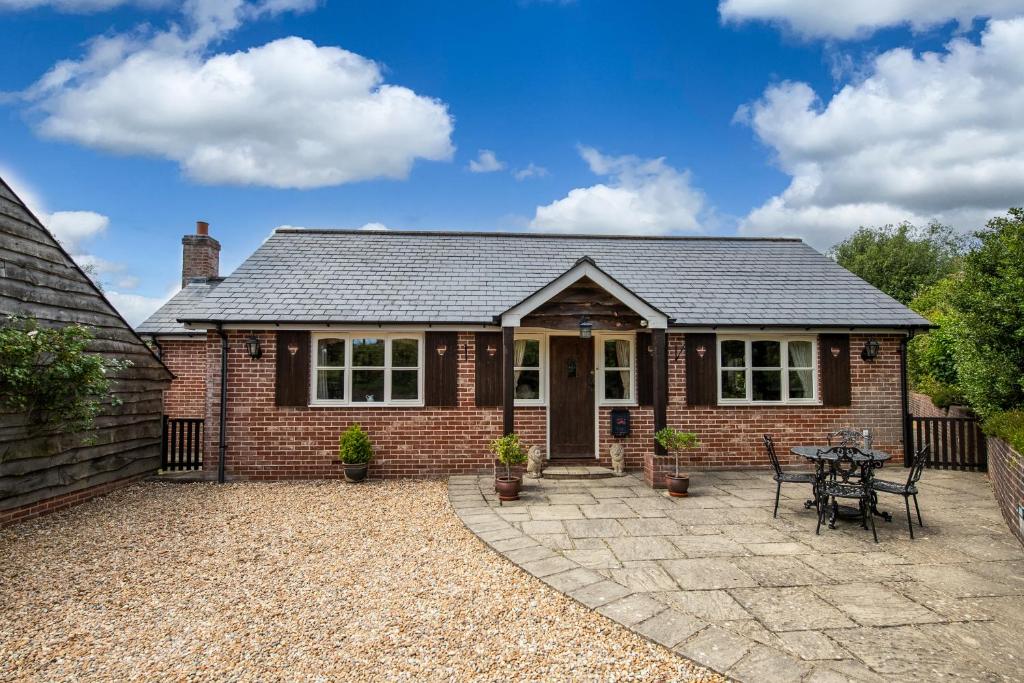 a brick house with a patio in front of it at Oak Tree Cottage, Charming, Rural New Forest Home in Boldre
