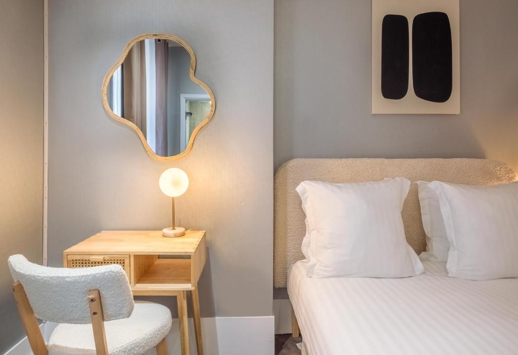 巴黎的住宿－Makom Pereire，一间卧室配有一张床、镜子和椅子