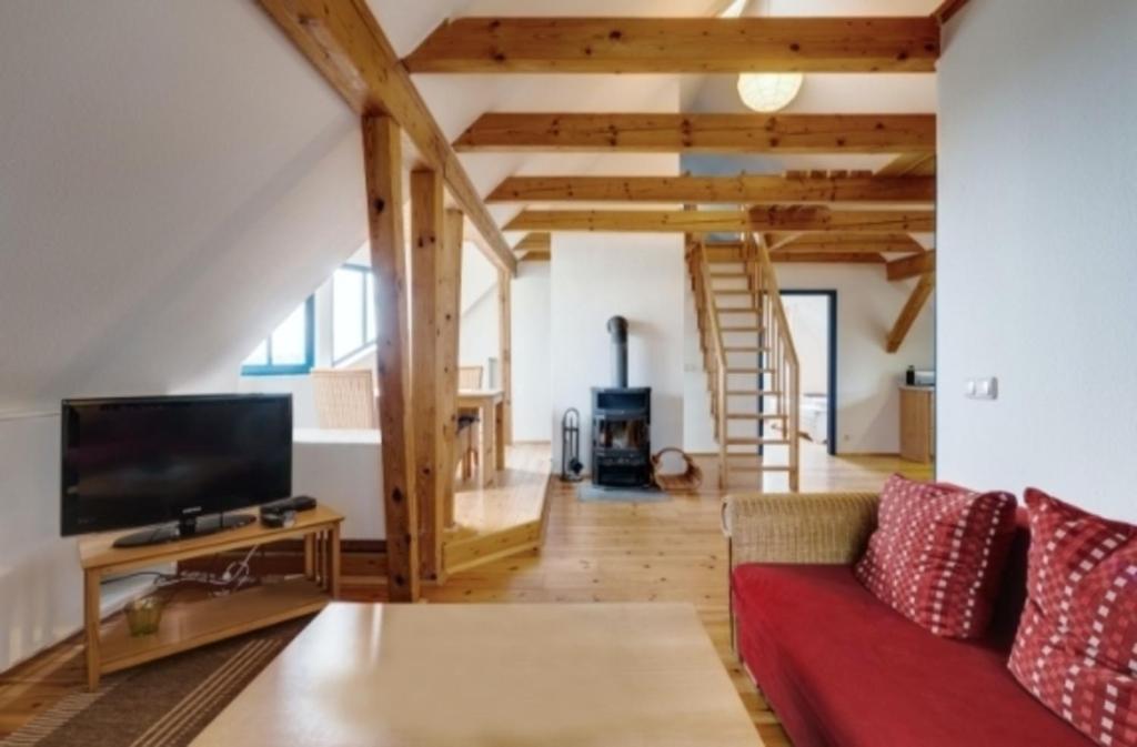 a living room with a red couch and a tv at 3-Raum Dachgeschoss Apartment 54 in Rankwitz