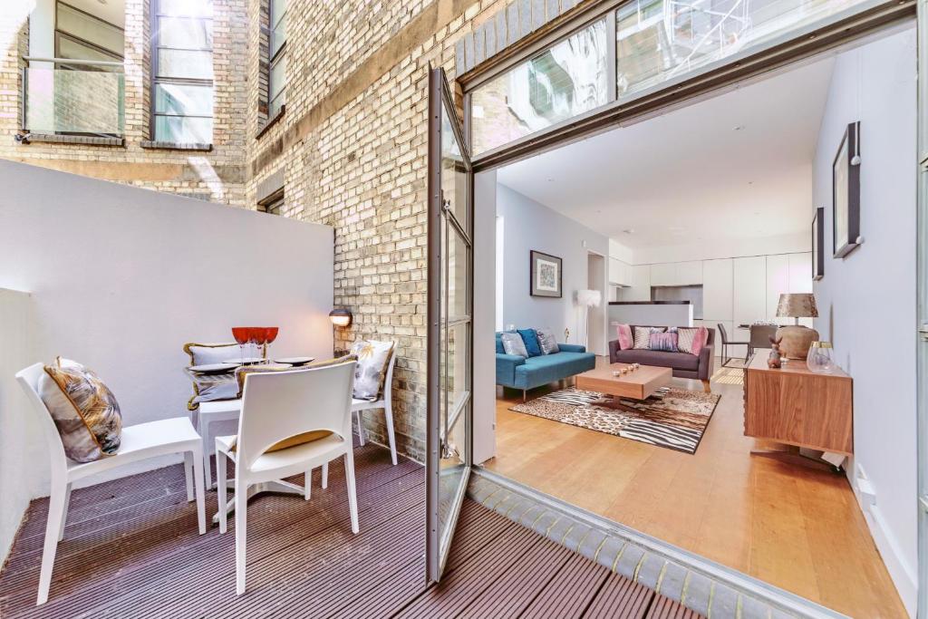 comedor y sala de estar con pared de ladrillo en Interior-Designer Apartment with 2 TERRACES, en Londres