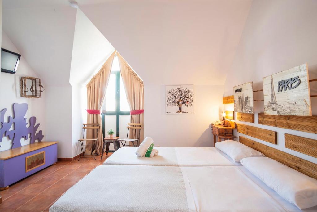 - une chambre avec un grand lit et une grande fenêtre dans l'établissement Hotel Doña Matilde, à Estepona