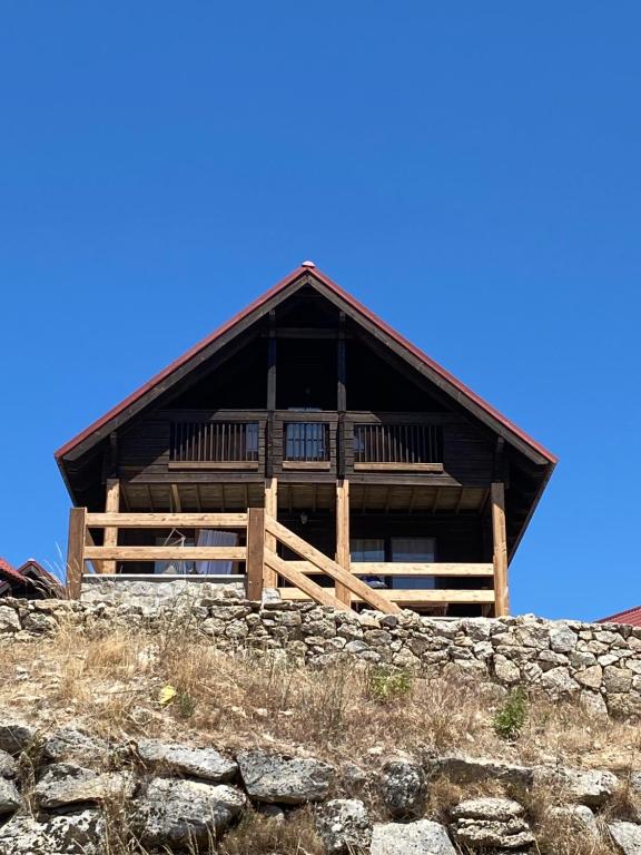 een groot houten gebouw bovenop een heuvel bij Chalé 21 in Cortes do Meio