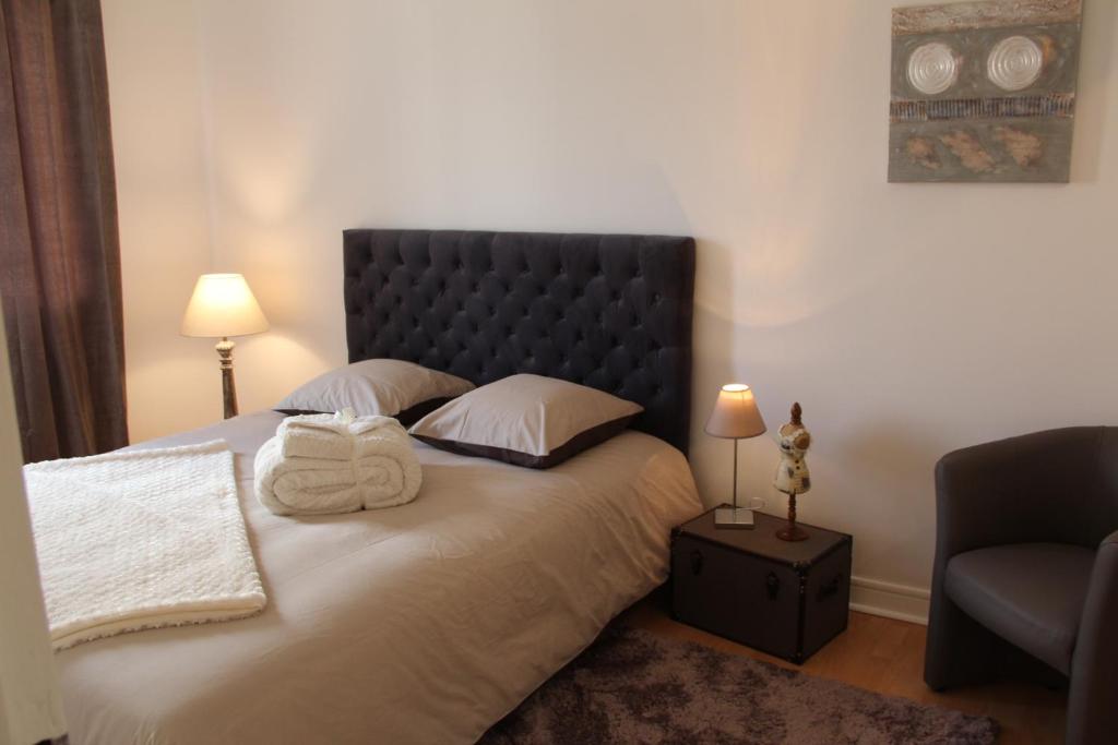 a bedroom with a bed with two towels on it at Apart'hotel Les Floralies in Roanne