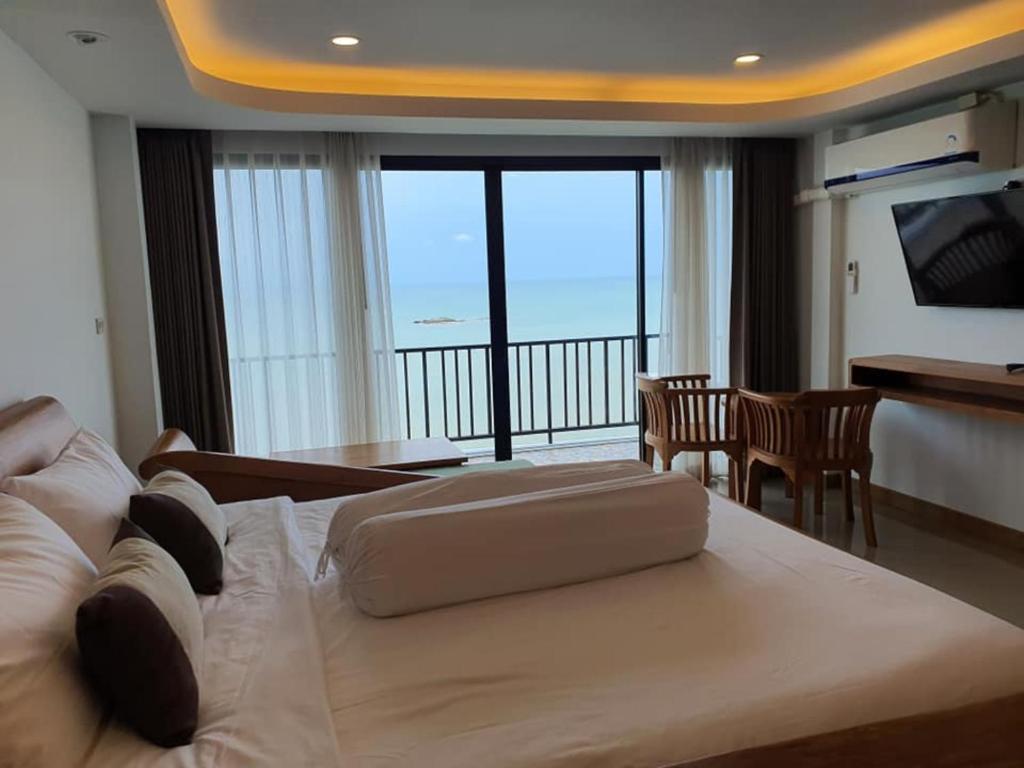 a hotel room with a large bed and a balcony at Grace Seaview บ้านพักส่วนตัว 3 ห้องนอน วิวทะเล หาดพลา in Ban Phala