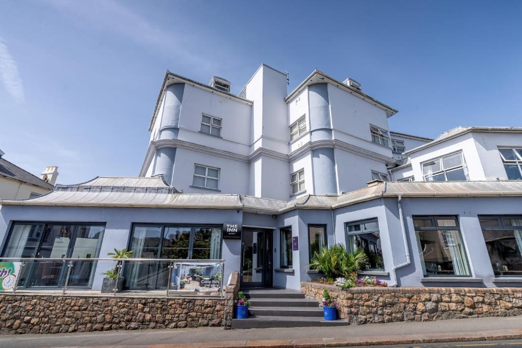 a large white building with windows at THE INN Hotel Bar and Restaurant in Saint Helier Jersey