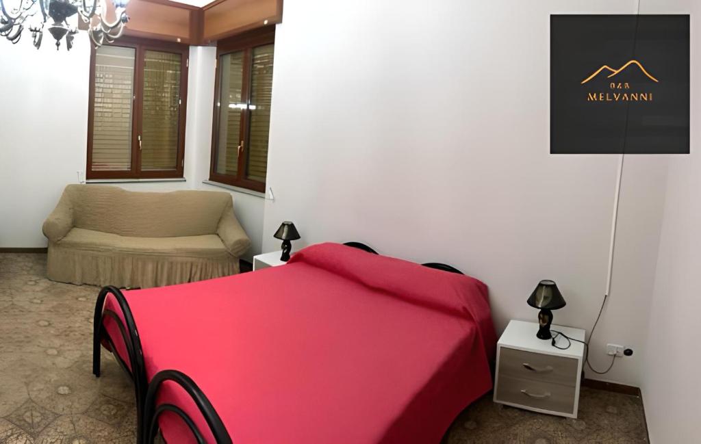 - une chambre avec un lit rouge et une chaise dans l'établissement Melvanni, à Pomigliano dʼArco