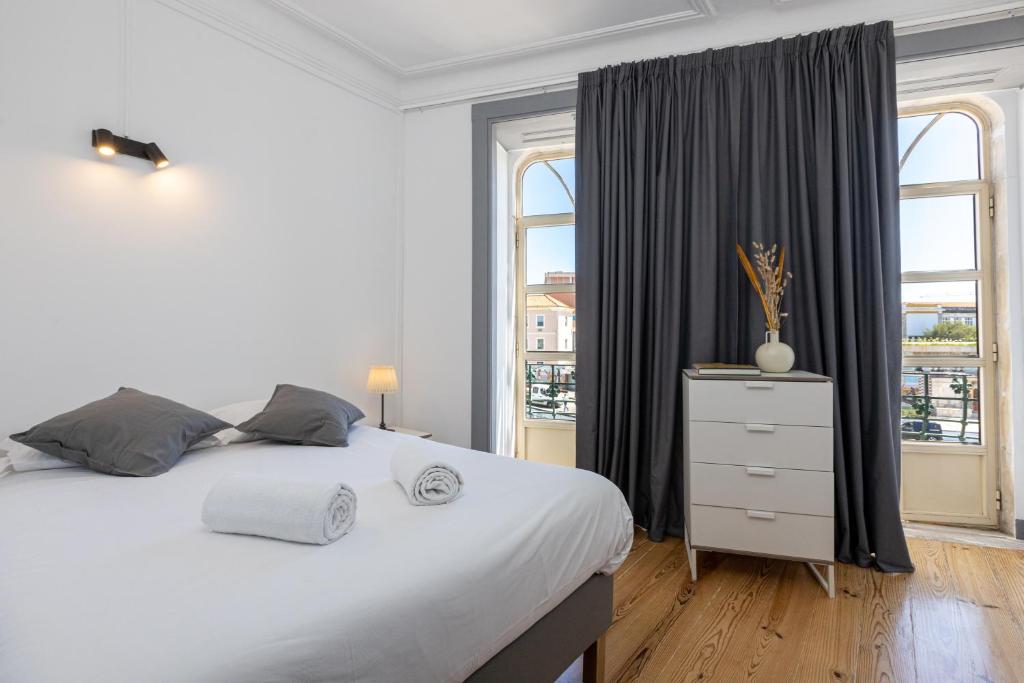 - une chambre avec un grand lit blanc et une fenêtre dans l'établissement Sleep in Centre - Aveiro, à Aveiro