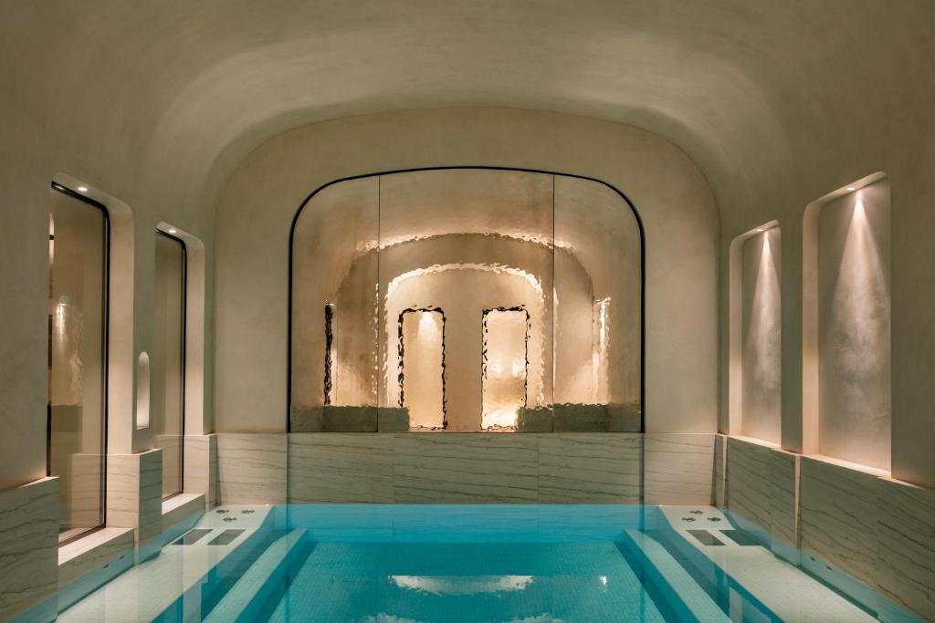 uma piscina num quarto com um espelho grande em Pavillon Faubourg Saint-Germain & Spa em Paris