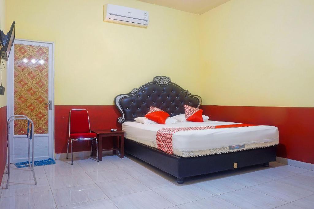 1 dormitorio con 1 cama y 1 silla en OYO 91433 Hotel Sari Jeneponto en Jeneponto