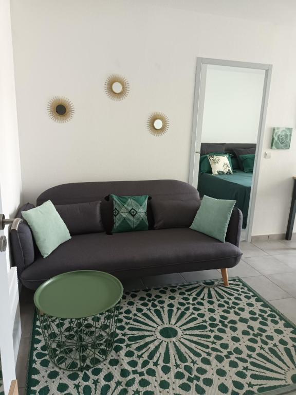 uma sala de estar com um sofá, uma mesa e um espelho em Superbe appartement et Parking proche du Centre du Monde em Perpignan