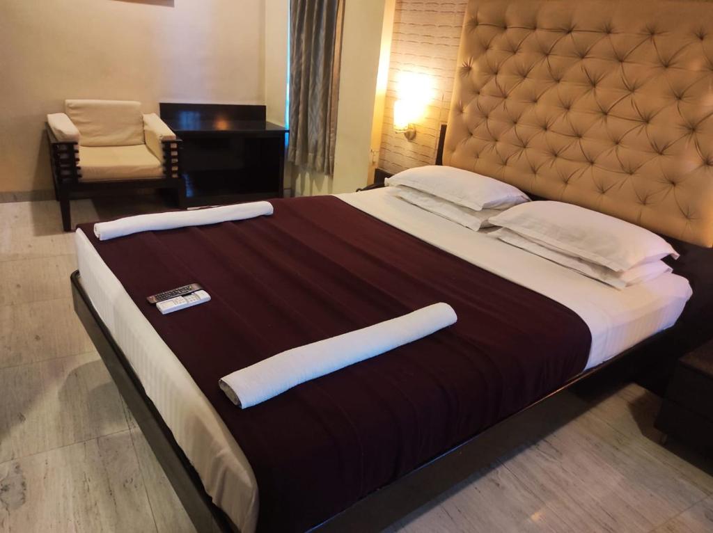 a large bed with a large headboard in a room at Hotel Vaishnavi in Solapur