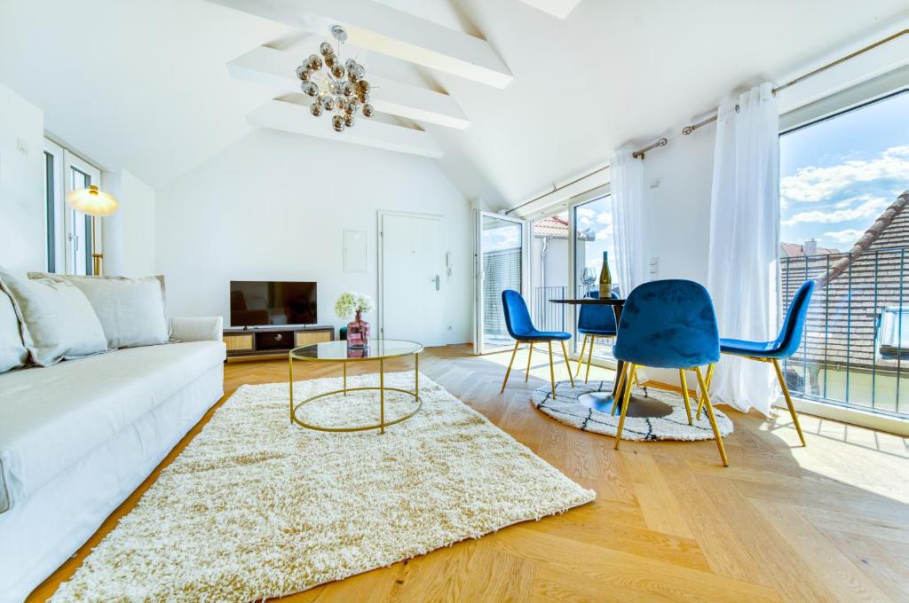 sala de estar con sofá blanco y sillas azules en Smile Apartments Burggasse en Krems an der Donau