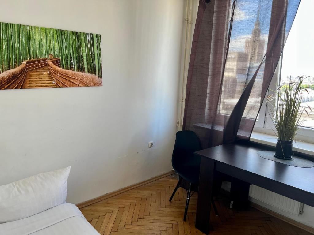 ワルシャワにあるWspólna Apartmentのデスク、テーブル、窓が備わる客室です。