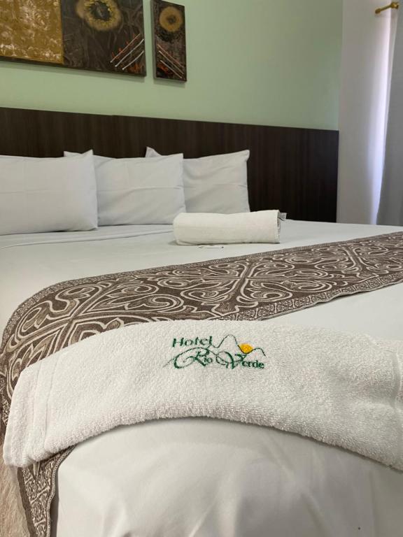 a bed with a white towel on top of it at Hotel Rio Verde in Dianópolis