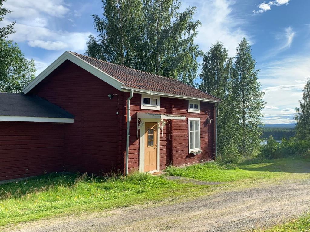 a small red house with a yellow door at Bogärdan, cozy cabin by the Luleå River in Harads