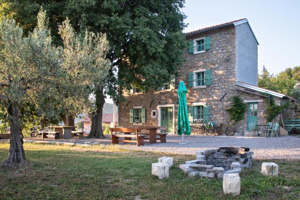 ポルトロスにあるIstrian Casa Ladonia by Locap Groupのテーブルと緑傘の建物