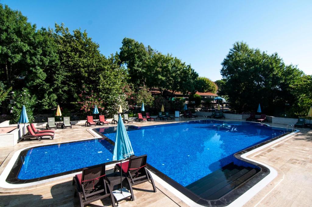uma grande piscina com cadeiras e guarda-sóis em Fener Motel em Şile