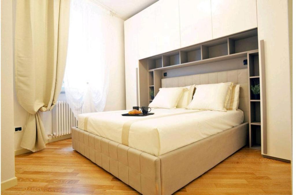a large white bed in a room with a window at VENTUNO - Modern Apartment - Country & Lake in Lovere
