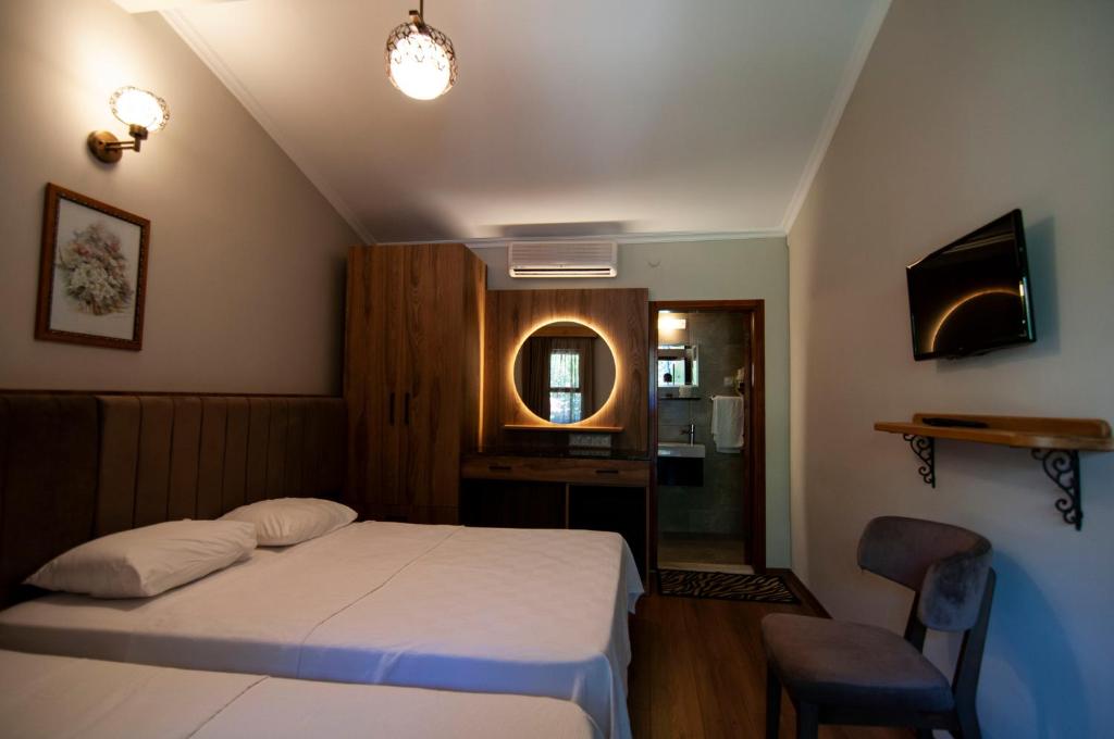 a small bedroom with a bed and a mirror at Fener Motel in Şile
