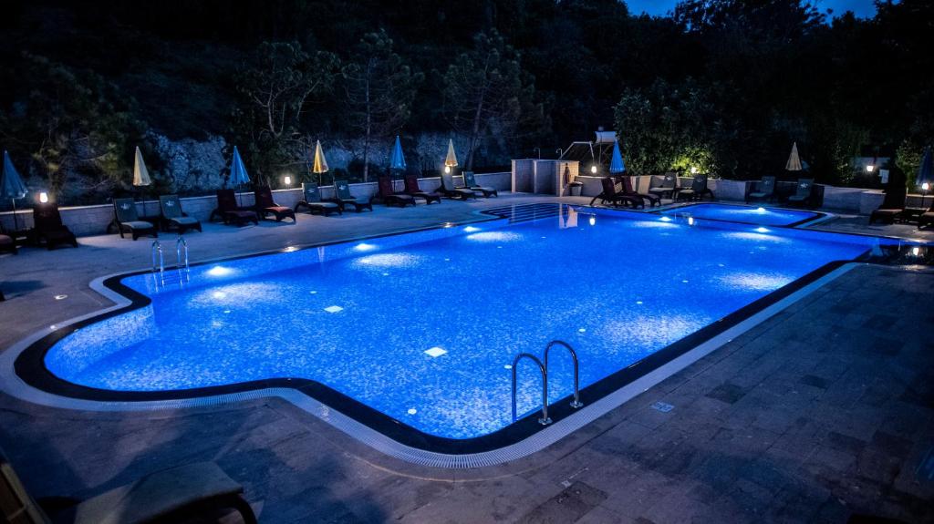 a swimming pool at night with lights on it at Fener Motel in Şile
