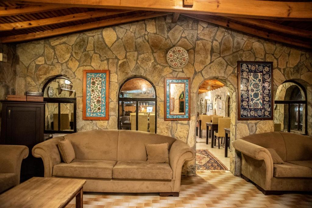 a living room with two couches and a stone wall at Fener Motel in Şile