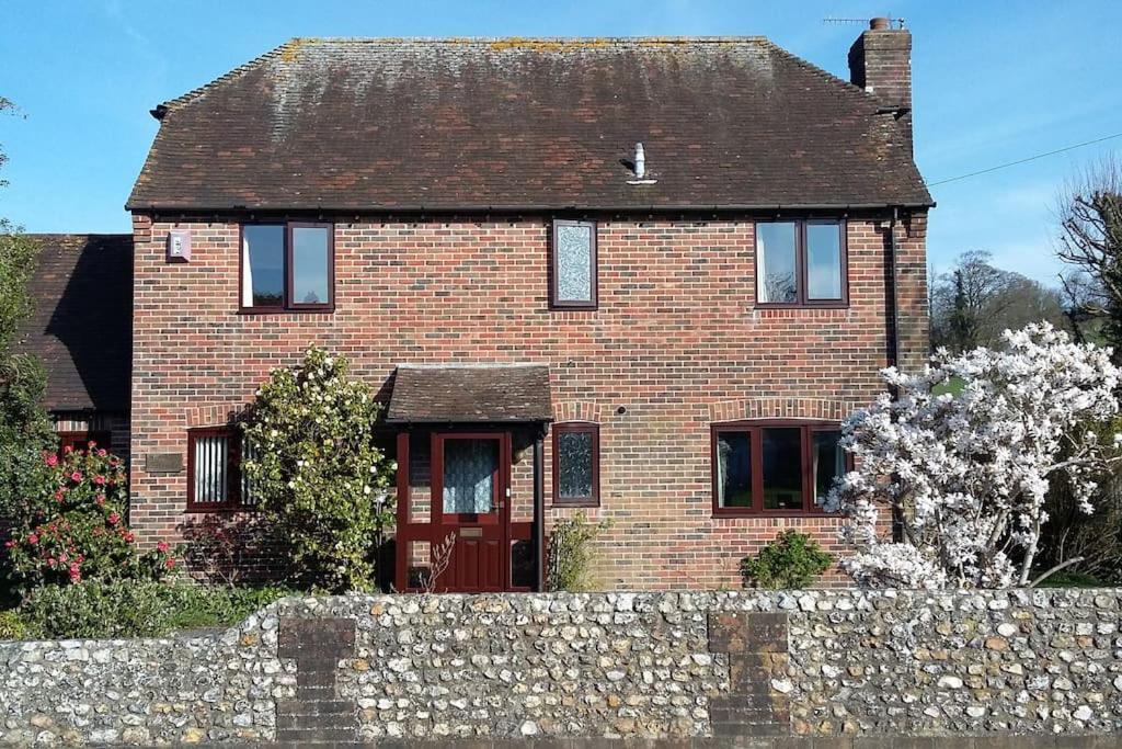 una casa de ladrillo rojo con una pared de piedra en Bramley Cottage Holidays, en Chichester