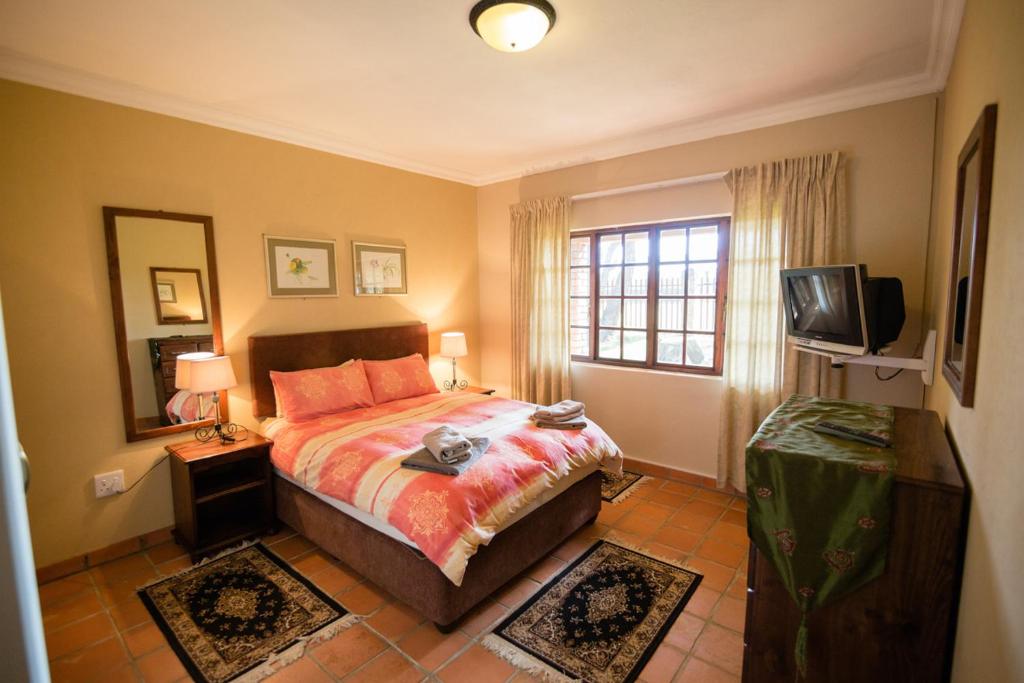 a bedroom with a bed and a television in it at Paul's Place in Dullstroom
