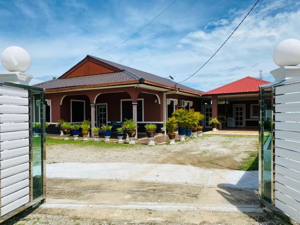 a house with a gate in front of it at ALOR SENARI HOMESTAY PRIVATE POOL in Pantai Cenang