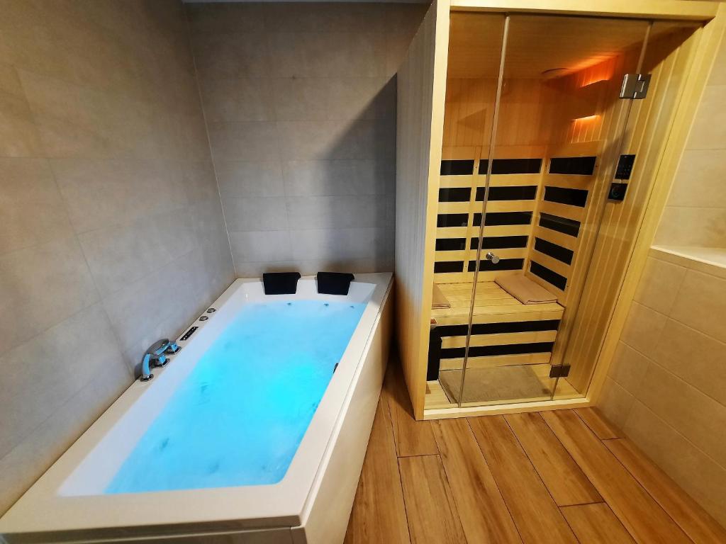 y baño con bañera y ducha. en Apartments Hlapi with SPA en Kobarid