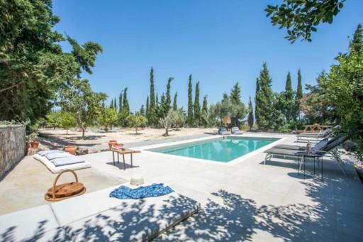 a swimming pool with a table and chairs next to it at Villa Kora in Kallithea Rhodes