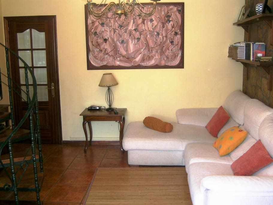 a living room with a white couch and a table at Antia - Casita de piedra en Lariño in Carnota