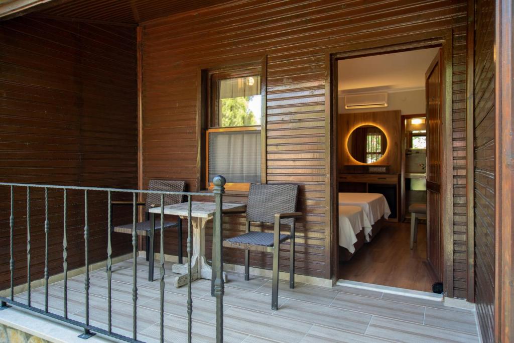 a balcony with a table and chairs and a bedroom at Fener Motel in Şile