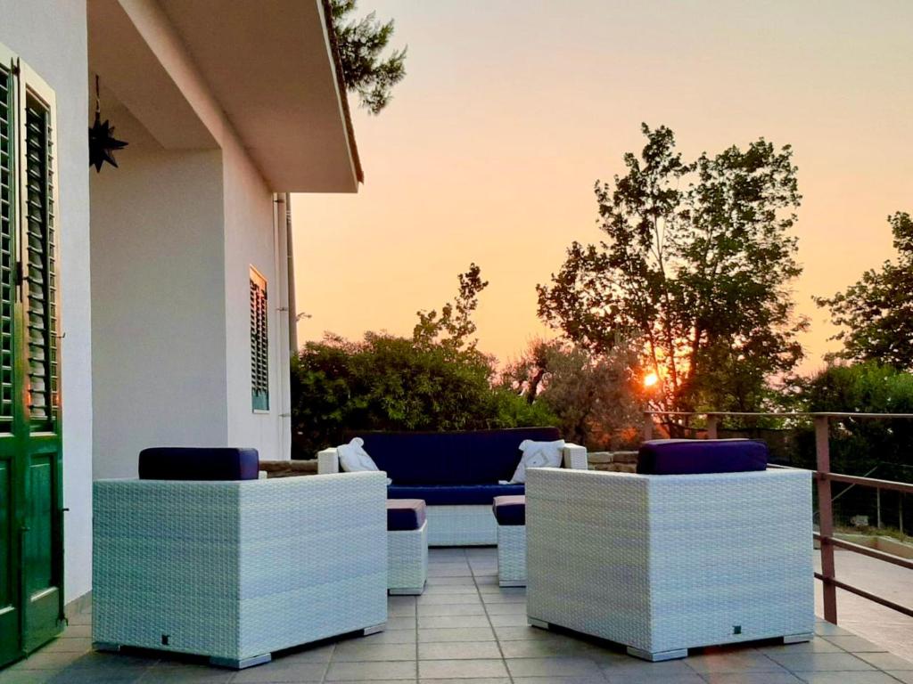 eine Terrasse mit Stühlen und einem Sofa auf dem Balkon in der Unterkunft RELAIS COUNTRY HOUSE - TERRACE on AEOLIAN ISLANDS in Acquedolci