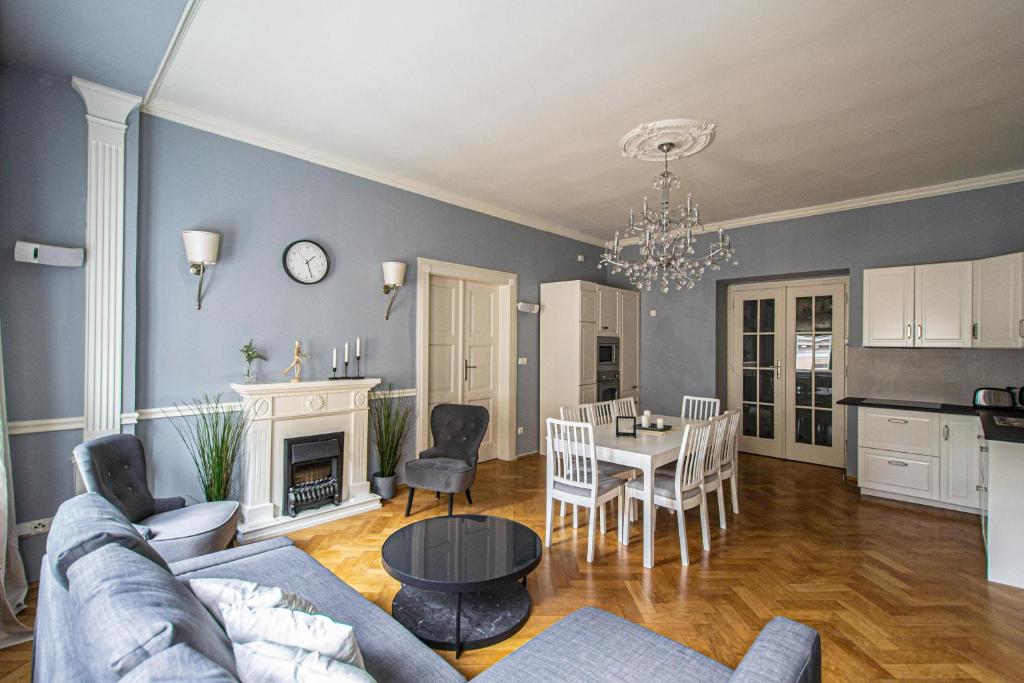Il comprend un salon et une cuisine avec un canapé et une table. dans l'établissement Luxury Central 150m2 Apartment on Wencelas Square with Private Garage, à Prague