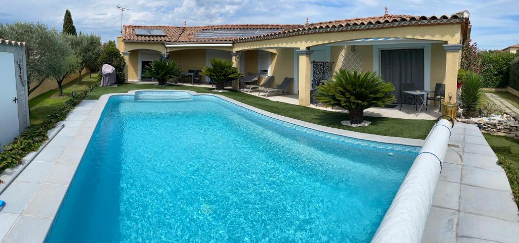 a swimming pool in front of a house at Chambre avec charme in Garons