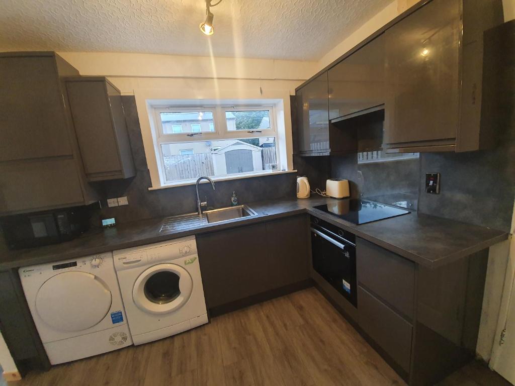 a kitchen with a sink and a washing machine at Homie in Aberdeen