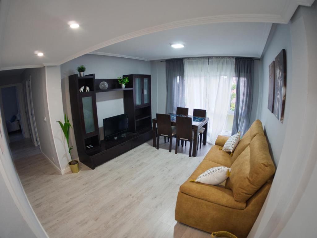 ein Wohnzimmer mit Couch und ein Esszimmer in der Unterkunft Bonito piso Villafria in Oviedo