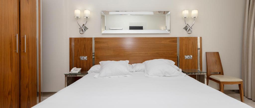 Postel nebo postele na pokoji v ubytování Gran Hotel Corona Sol