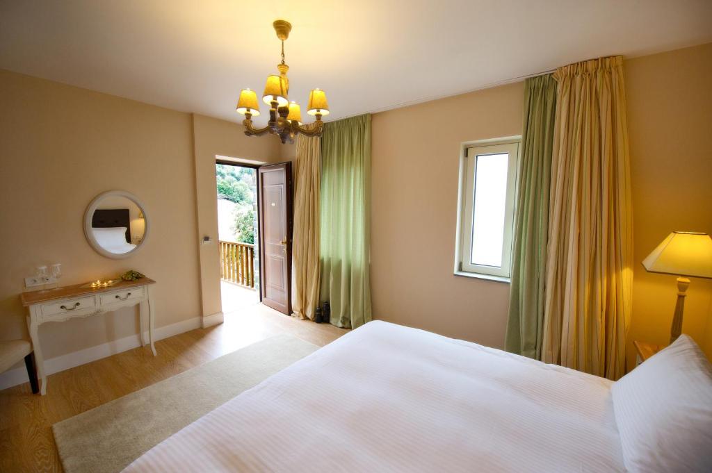 Un dormitorio con una gran cama blanca y una ventana en Mir Boutique Hotel, en Ioannina