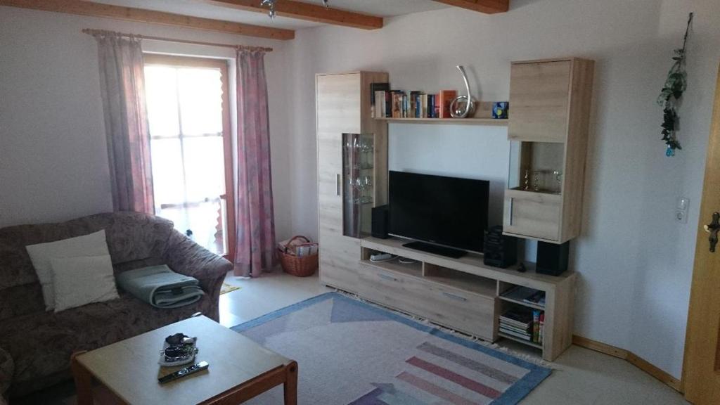 ein Wohnzimmer mit einem TV, einem Sofa und einem Tisch in der Unterkunft Ferienwohnung Piller in Hohenau