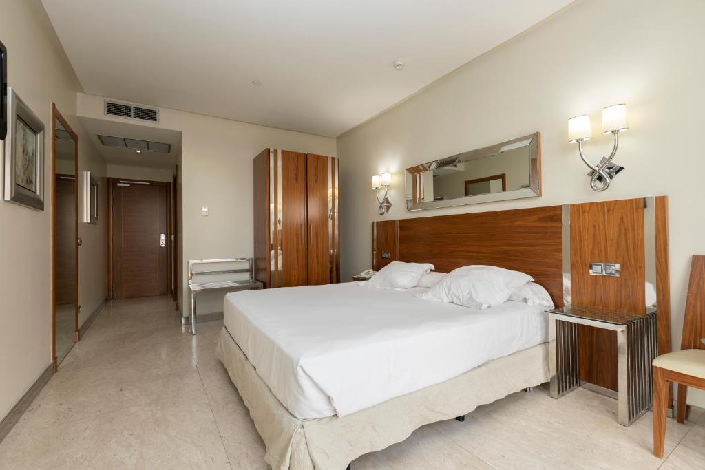 Postel nebo postele na pokoji v ubytování Gran Hotel Corona Sol