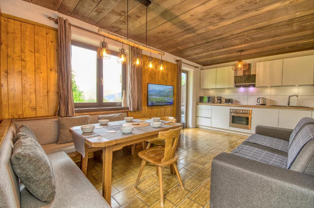 Il comprend un salon avec une table et une cuisine. dans l'établissement Haus Kitzsteinhorn 6 - by Alpen Apartments, à Kaprun