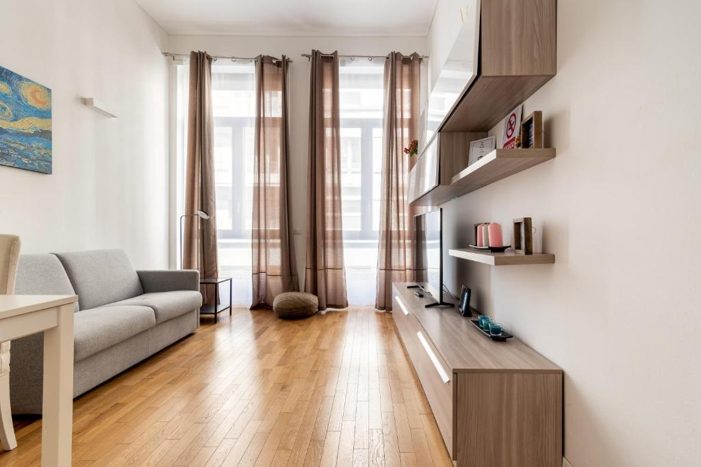 een woonkamer met een bank en een tafel bij Duomo Apartment - Diaz in Milaan
