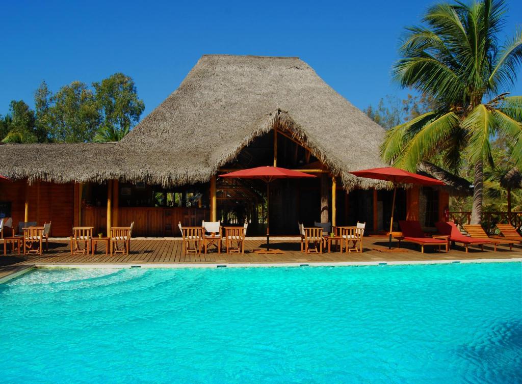 un complexe avec des tables et des chaises et une piscine dans l'établissement Hôtel **** Palissandre Côte Ouest, à Morondava