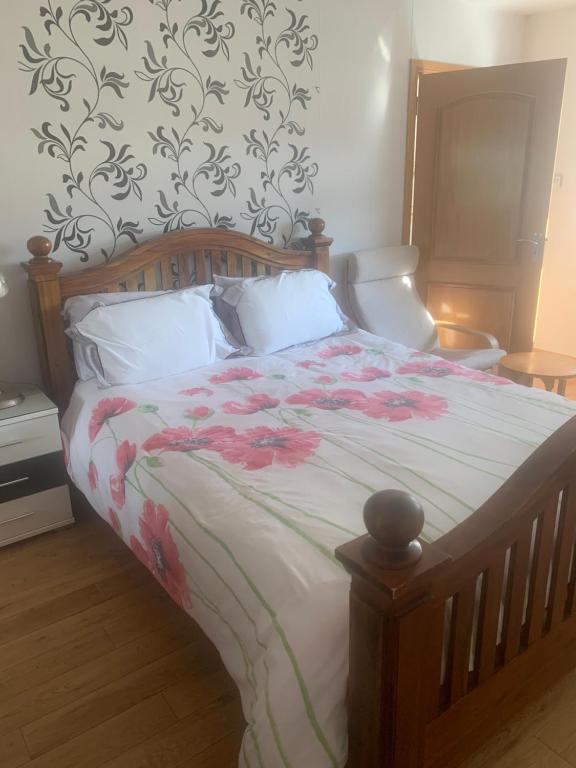 a bedroom with a large bed with flowers on it at Acer Guest House in Perth
