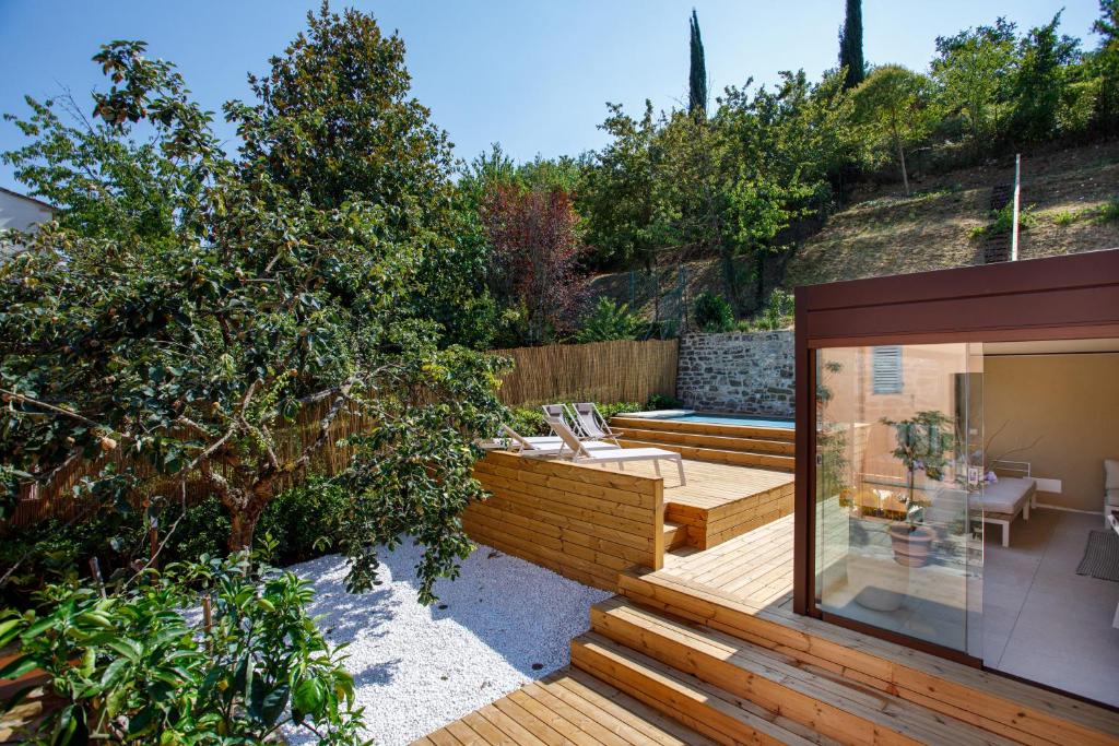 un jardin avec une terrasse en bois et une maison dans l'établissement Casa Vacanze Alessandro 2, à Greve in Chianti
