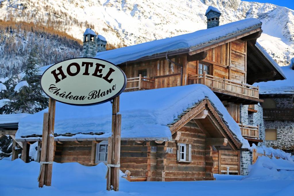 a hotel sign in front of a log cabin at Relais du Chateau Blanc in La Thuile
