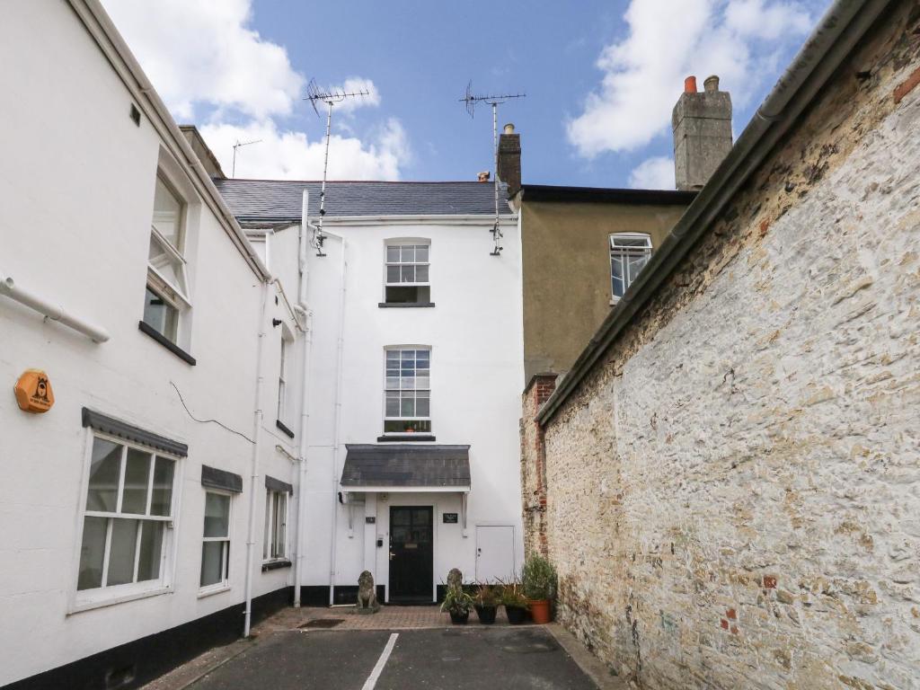 uma vista para a rua de uma casa branca e de um edifício em The Town House em Dorchester