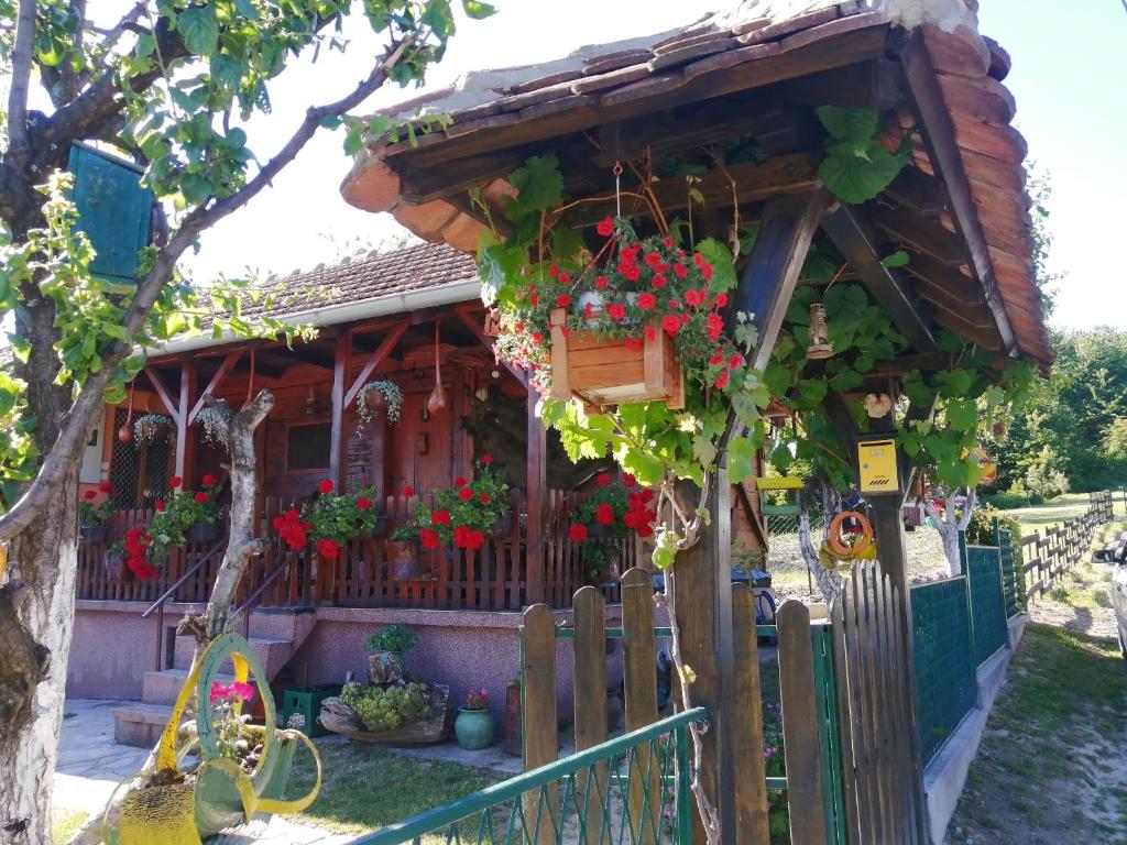 a small house with flowers in a fence at Mala Kelja in Rudnik