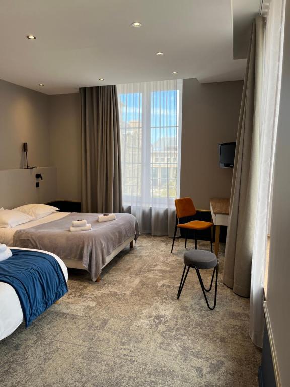 Habitación de hotel con cama y silla en Hotel Brasserie Armoricaine, en Saint-Malo